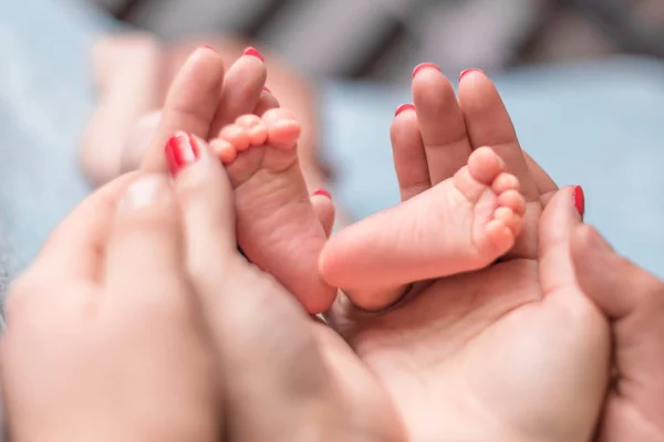 Pies de bebé en manos de madre — Foto de Stock