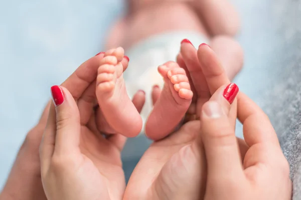 Pies de bebé en manos de madre — Foto de Stock