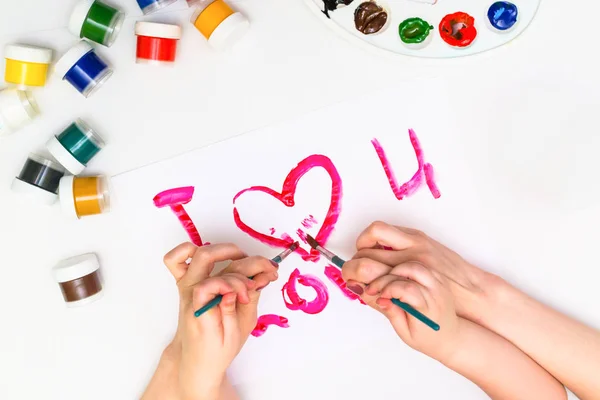 Les mains des enfants peignent un cœur — Photo