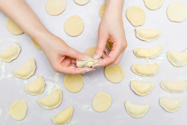 Womans hands make ravioli