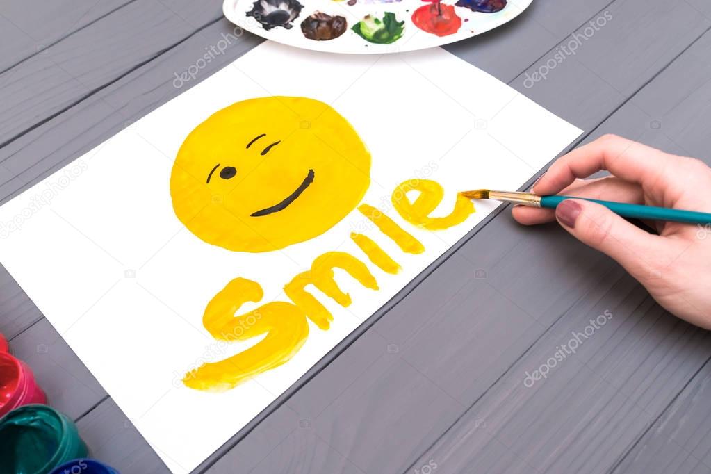 Hand draws smile on sheet