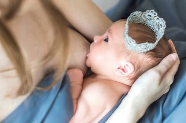 Anne yeni doğmuş bebeğini emziriyor.