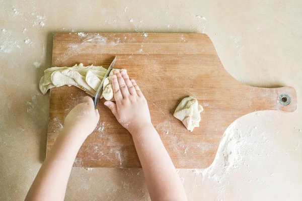 Manos de los niños cortar masa cruda —  Fotos de Stock