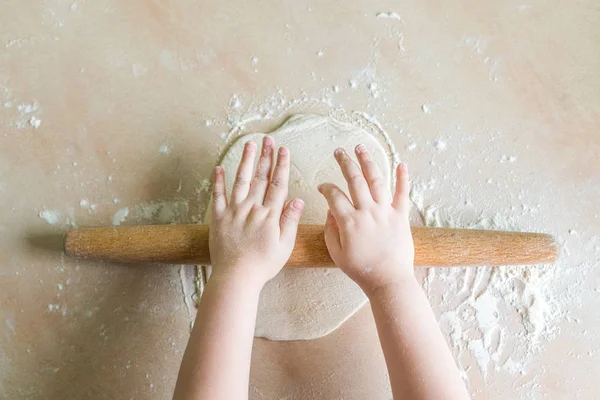 Childrens hands rolled dough — Stock Photo, Image