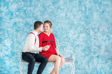 Seven bir bankta oturan, birbirine bakarak ve birbirlerine bir bankta dokunmadan genç çift. Bir bankta oturan kadın ve erkek. Stüdyo çekim