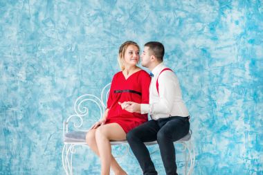 Seven bir bankta oturan, birbirine bakarak ve birbirlerine bir bankta dokunmadan genç çift. Bir bankta oturan kadın ve erkek. Stüdyo çekim