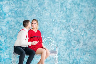 Seven bir bankta oturan, birbirine bakarak ve birbirlerine bir bankta dokunmadan genç çift. Bir bankta oturan kadın ve erkek. Stüdyo çekim