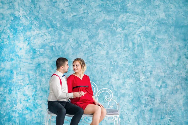 Seven bir bankta oturan, birbirine bakarak ve birbirlerine bir bankta dokunmadan genç çift. Bir bankta oturan kadın ve erkek. Stüdyo çekim