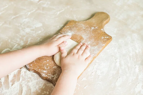 Дитячі руки роблять тісто — стокове фото