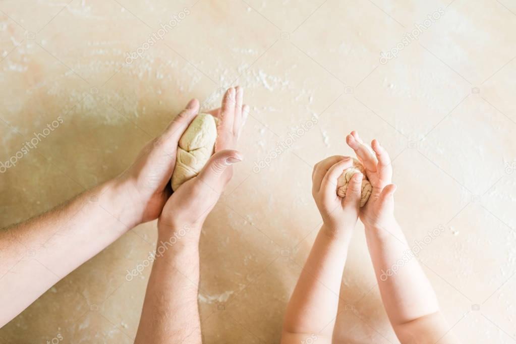 Childrens and dads hands makes raw dough