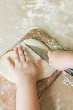 Bir çocuk çiğ hamur keser