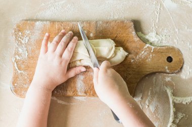 Bir çocuk çiğ hamur keser