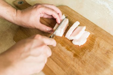 bir adam pişmemiş domuz yağı parçalar halinde keser.