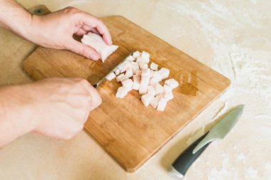 bir adam pişmemiş domuz yağı parçalar halinde keser.