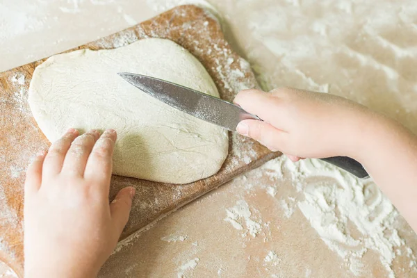 Bir çocuk çiğ hamur keser