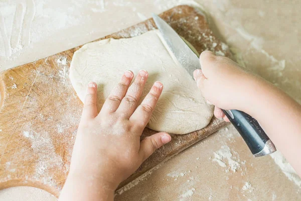 Bir çocuk çiğ hamur keser