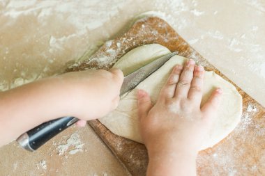 Bir çocuk çiğ hamur keser