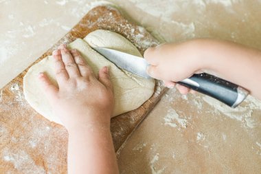 Bir çocuk çiğ hamur keser