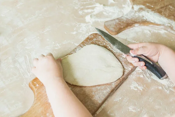 Bir çocuk çiğ hamur keser