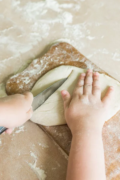 Bir çocuk çiğ hamur keser