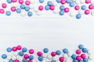 Beyaz ahşap arka plan üzerinde renkli nane kaplı şekerler doku çerçevesinden. Üstten Görünüm. Kopya alanı