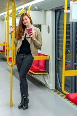 Bir fincan kahve bir boş metro treninin içinde kızla. Bir fincan kahve ile metro bir arabada kızdır