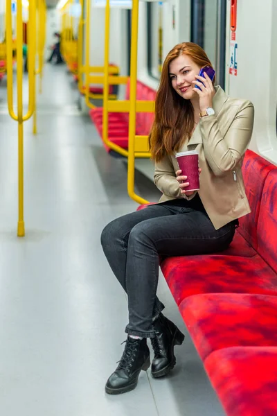 Das Mädchen spricht mit einem Handy in einem leeren U-Bahn-Zug — Stockfoto