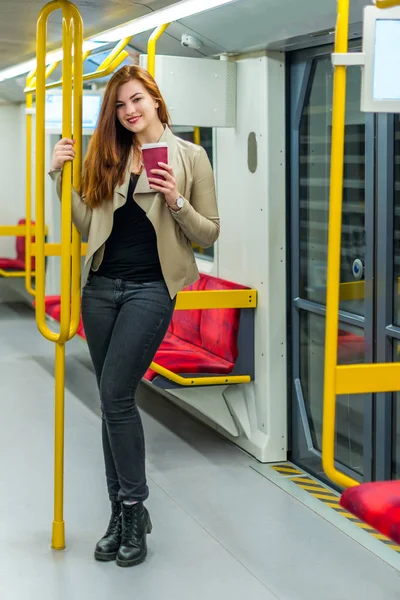 Bir fincan kahve bir boş metro treninin içinde kızla. Bir fincan kahve ile metro bir arabada kızdır