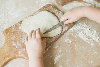 Bir çocuk çiğ hamur keser