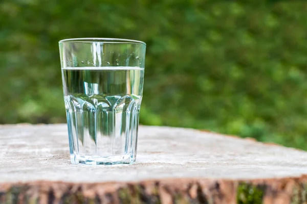 Склянка води на дерев'яному пні — стокове фото