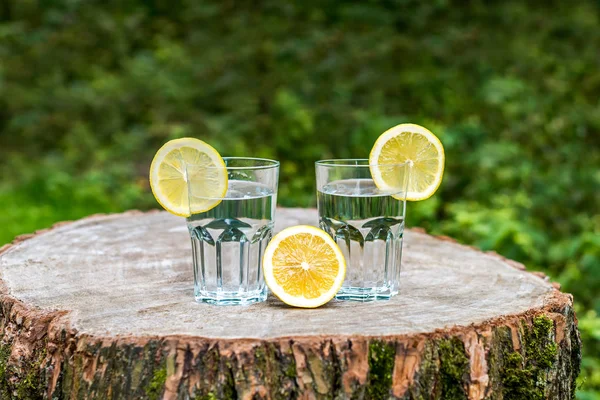Шматочки лимона на двох склянках води — стокове фото