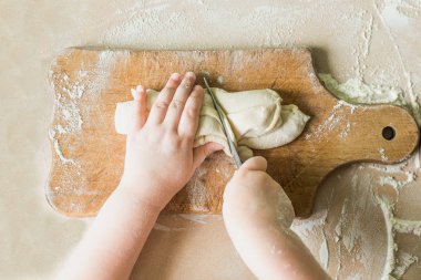 Bir çocuk çiğ hamur keser