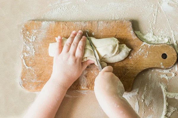 Bir çocuk çiğ hamur keser