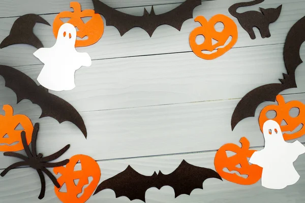 Cadılar Bayramı tatil çerçeve ile kabak, yarasalar, kedi, örümcek, arka plan yapılmış şapka ve hayaletler gri tahtada kağıt kesme. Uzay kopyalayın. Işık kadar