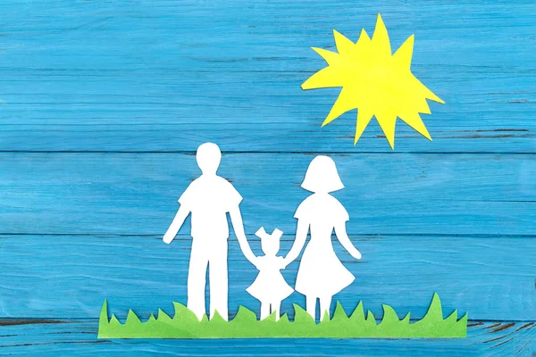 Papiersilhouette einer Familie, die im grünen Gras unter der Sonne steht — Stockfoto
