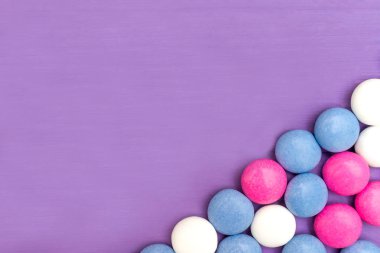 Ahşap mor zemin üzerine Üstten Görünüm alt sağ köşesinde çerçevesinin renkli Çikolata kaplamalı şeker. Kopya alanı