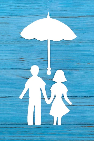 Papper silhuetten av man och kvinna som håller händerna under paraply — Stockfoto