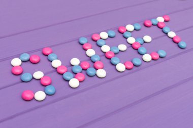 Tatlı mor arka plan üzerinde renkli şekerler yapılmış word'ün resim