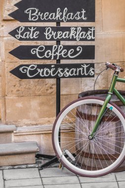 Hangi ahşap bir varil ve işaretçiler yakın bisiklet olduğunu yazılı Kahvaltı, kahve, ay çöreği