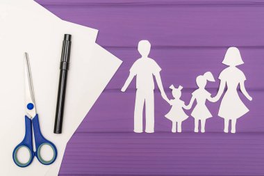 Erkek ve kadın iki kızla kağıt kesme siluetleri