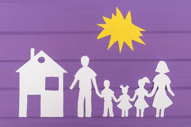 Erkek ve kadın ile iki kız ve erkek güneş, evin yakınına altında kağıt bitti siluetleri kesmek