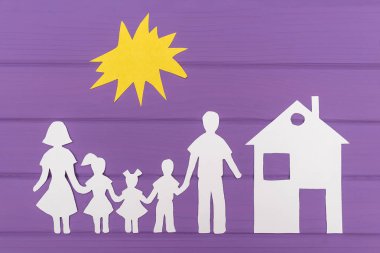 Erkek ve kadın ile iki kız ve erkek güneş, evin yakınına altında kağıt bitti siluetleri kesmek