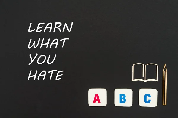 Letras ABC e miniatura aglomerado no quadro negro com texto aprender o que você odeia — Fotografia de Stock