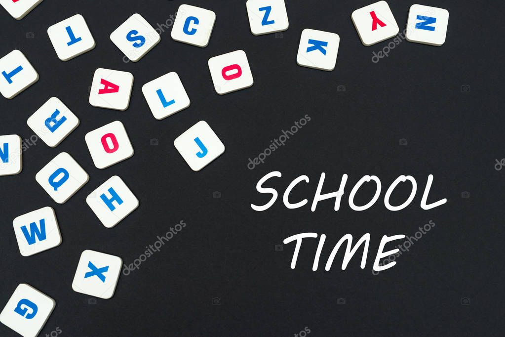 english colored square letters scattered on black background with text school time