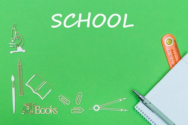 Text school, school supplies wooden miniatures, notebook with ruler, pen on green backboard — Stock Photo, Image