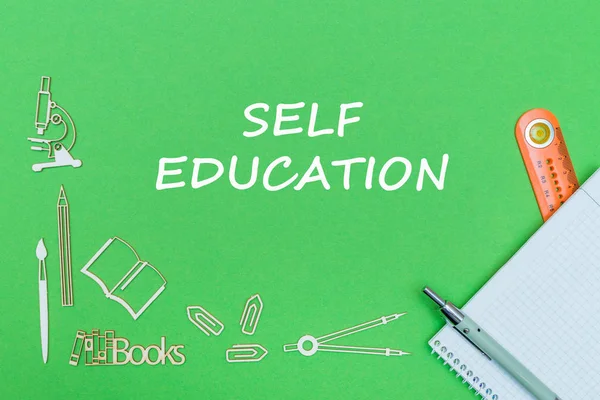 Texto auto-educação, escola fornece miniaturas de madeira, notebook com régua, caneta no backboard verde — Fotografia de Stock