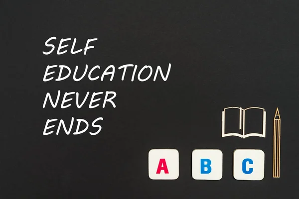 Abc letras e aglomerado miniatura no quadro negro com texto auto-educação nunca termina — Fotografia de Stock