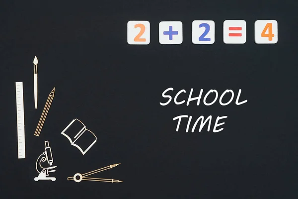 Fournitures scolaires placées sur fond noir avec texte temps scolaire — Photo