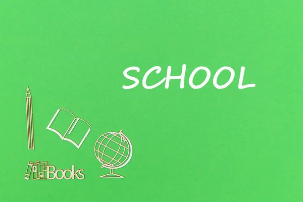 Escuela de texto, material escolar miniaturas de madera sobre fondo verde — Foto de Stock