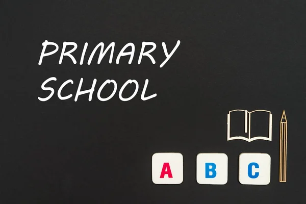 Abc letters and chipboard miniature on blackboard with text primary school — Stock Photo, Image